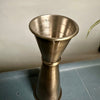Bronze metal jigger on a gray surface with a neutral background