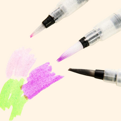 Three brush pens with colored tips on a white background